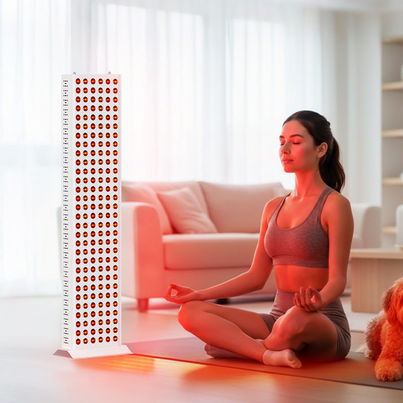 Woman meditating at home with red light therapy panel for muscle recovery and skin health