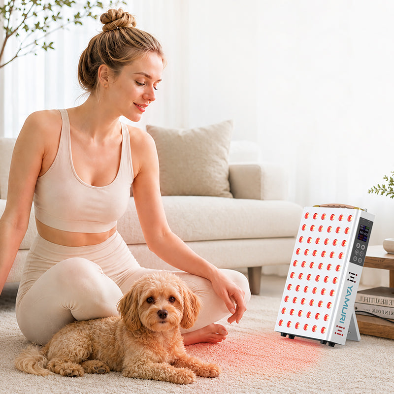 Woman relaxing with her dog beside the illuminated YA60-2W7 red light therapy panel in a living room