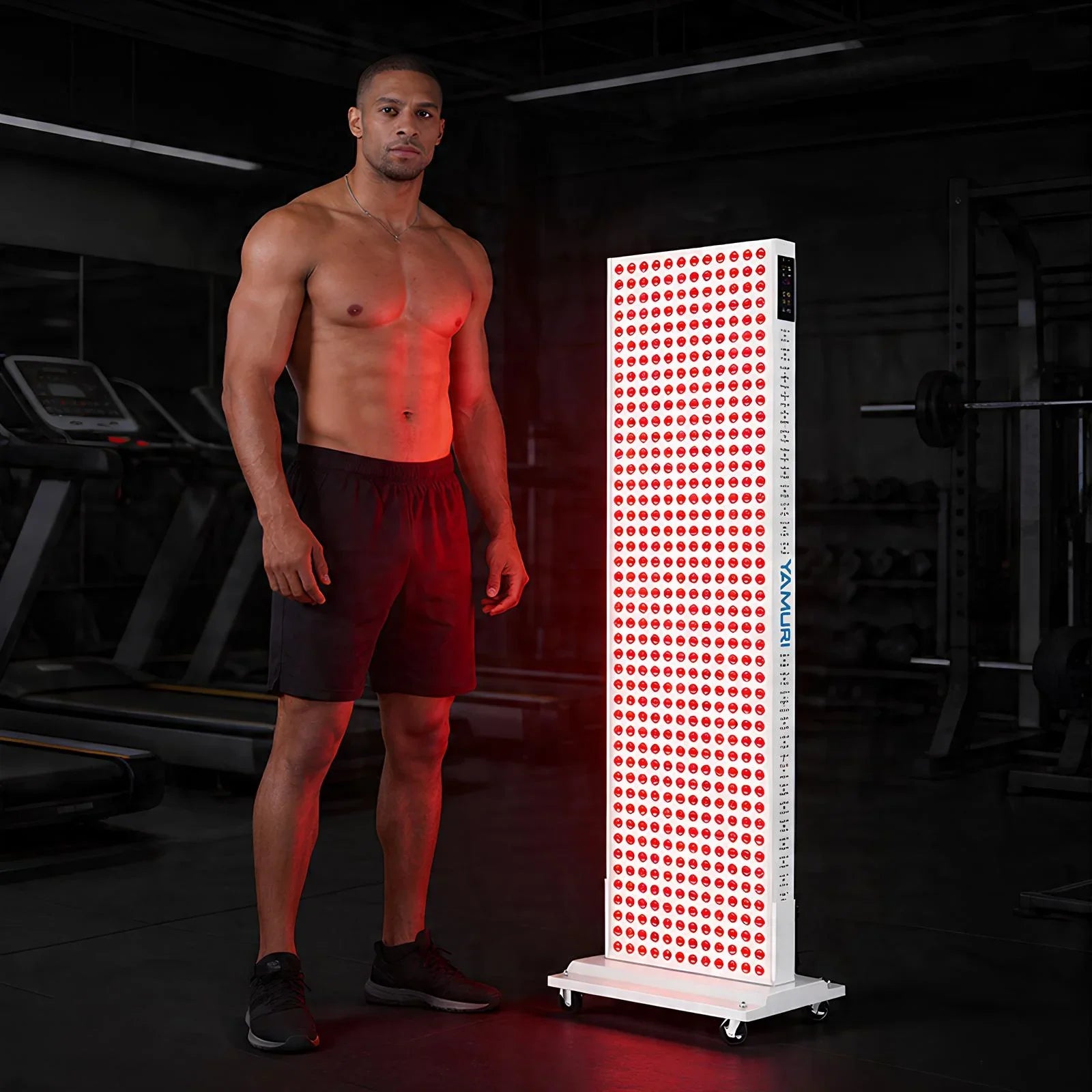Man using red light therapy panel in gym for muscle recovery and skin health