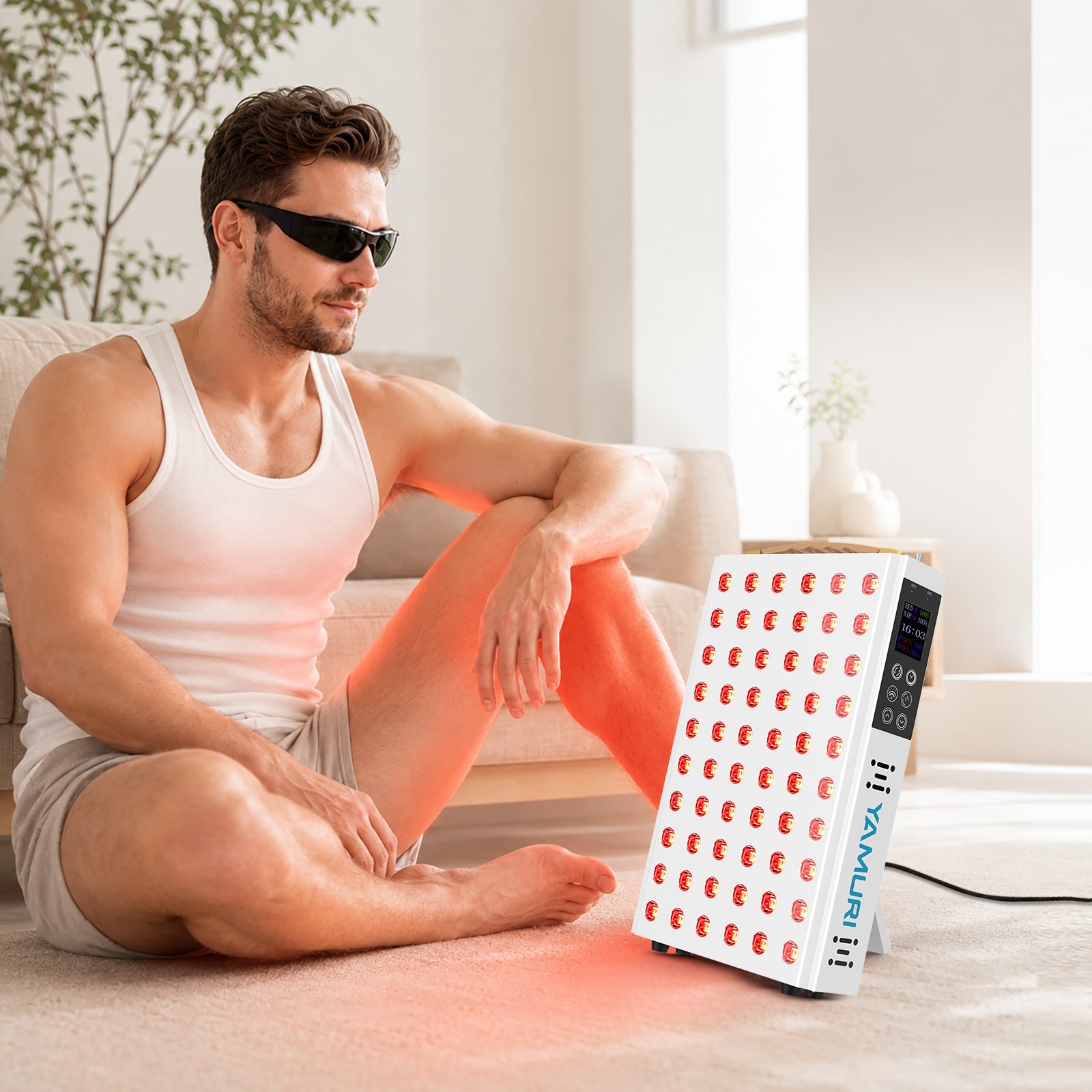 Man wearing protective eyewear beside the YA60-2W7 panel during a seated at-home red light therapy session
