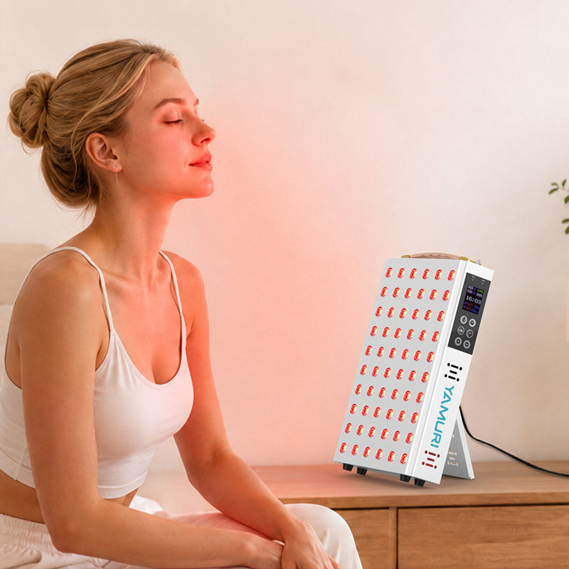 Woman seated at home using the illuminated YA60-2W7 red light therapy panel for a face and upper-body wellness routine