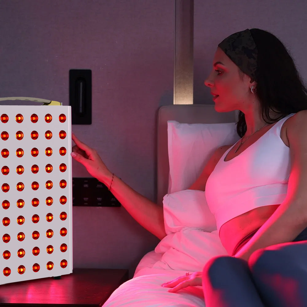 Woman using red light therapy panel at home for skin and muscle recovery